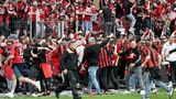 Leverkusener Fans stürmen nach dem Sieg auf das Spielfeld