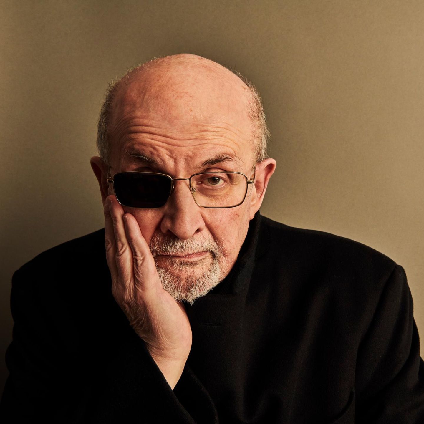 Portrait Salman Rushdie lehnt seinen Kopf auf eine Hand und trägt eine Augenklappe