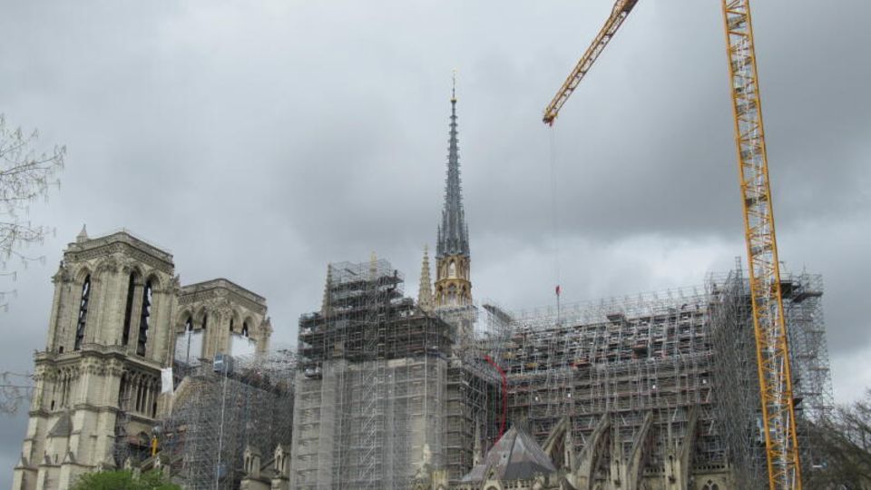 Die Notre Dame, eingekleidet in ein Baugerüst, daneben ein Kran