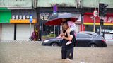 Ein Mann trägt ein kleines Mädchen auf den Schultern durch die Fluten in Guangzhou