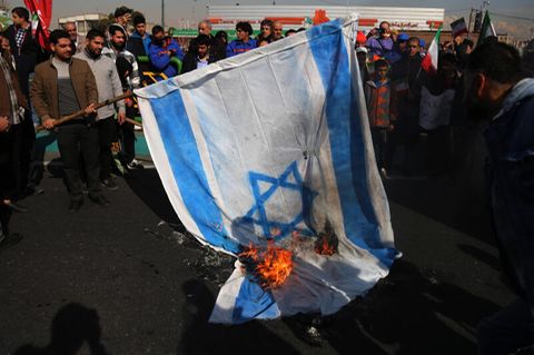 Menschen im Iran verbrennen eine Flagge Israels