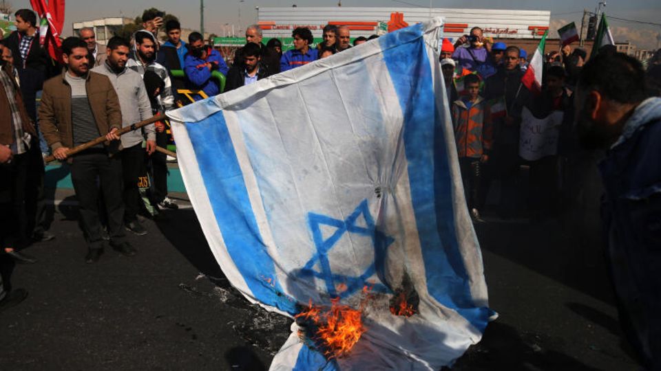 Menschen im Iran verbrennen eine israelische Flagge