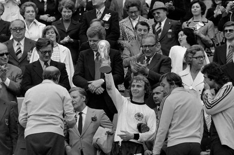 Hölzenbein stemmt nach dem Finale die WM-Trophäe in die Höhe, links neben ihm ist Bundeskanzler Helmut Schmidt zu sehen. Der Frankfurter Angreifer absolviert 40 Länderspiele und schießt fünf Tore im DFB-Trikot.