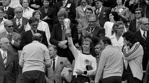 Hölzenbein stemmt nach dem Finale die WM-Trophäe in die Höhe, links neben ihm ist Bundeskanzler Helmut Schmidt zu sehen. Der Frankfurter Angreifer absolviert 40 Länderspiele und schießt fünf Tore im DFB-Trikot.