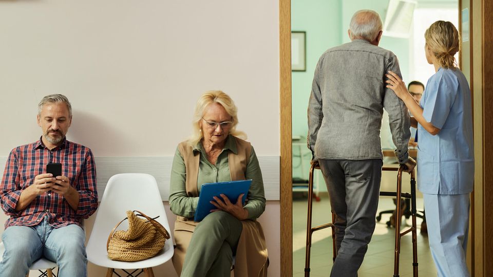 Ärztemangel: Menschen warten auf Stühlen, während ein Patient ins Behandlungszimmer geführt wird.