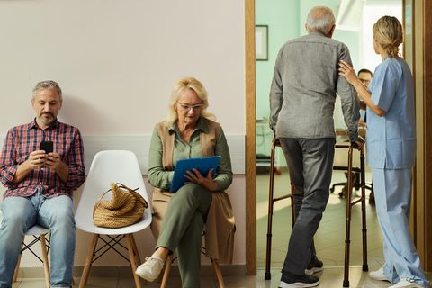 Ärztemangel: Menschen warten auf Stühlen, während ein Patient ins Behandlungszimmer geführt wird.