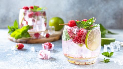 Wild Berry Spritz mit Beeren, Limette und Minze auf hölzernen Hintergrund
