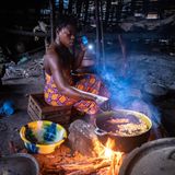 Gaya Bang kocht im Schein der Taschenlampe auf offenem Feuer.