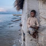 Der achtjährige Ndole Kamara sitzt auf einem Vorsprung der Hütte,
