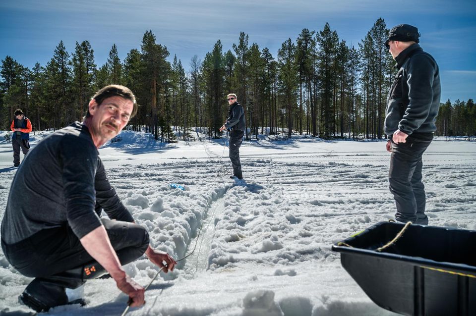 Männer verlegen ein Glasfaserkabel durch den Schnee Männer verlegen ein Glasfaserkabel durch den Schnee