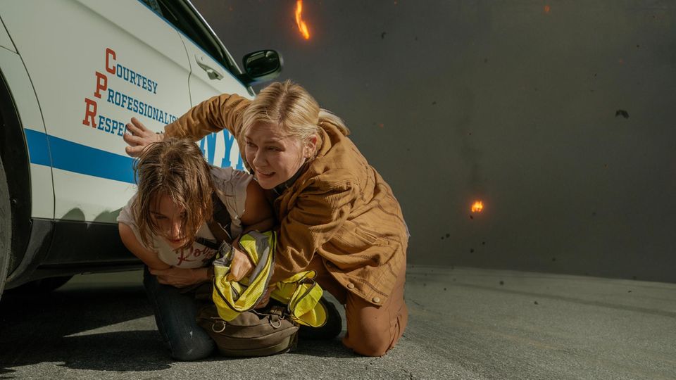 Szenenbild "Civil War": Zwei Frauen verstecken sich hinter einem NYPD-Auto