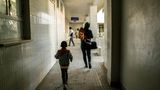 World Press Photo: Eine Frau und ein kleiner Junge von hinten, sie laufen einen gefliesten Gang entlang