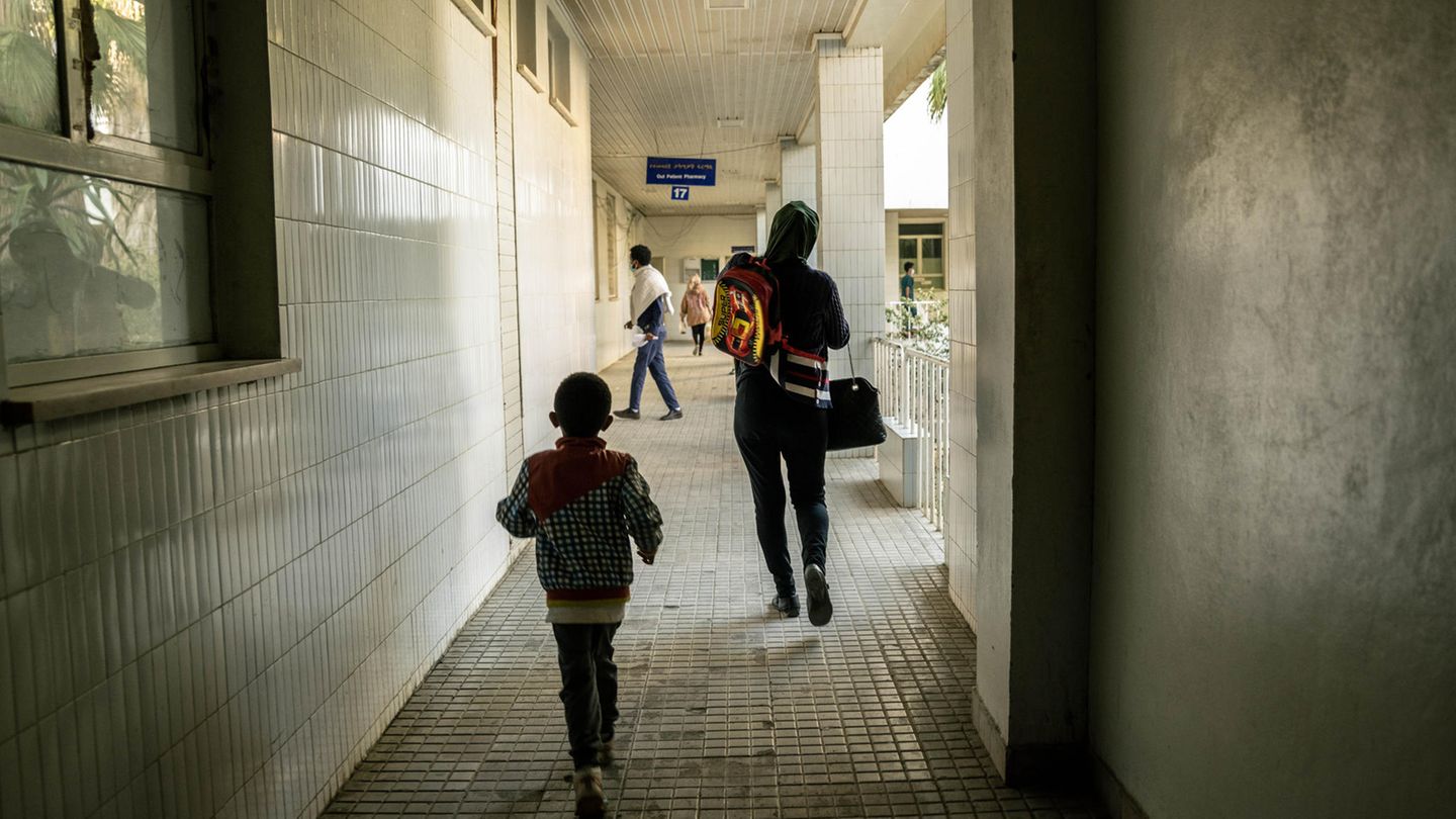 World Press Photo: Eine Frau und ein kleiner Junge von hinten, sie laufen einen gefliesten Gang entlang World Press Photo: Eine Frau und ein kleiner Junge von hinten, sie laufen einen gefliesten Gang entlang