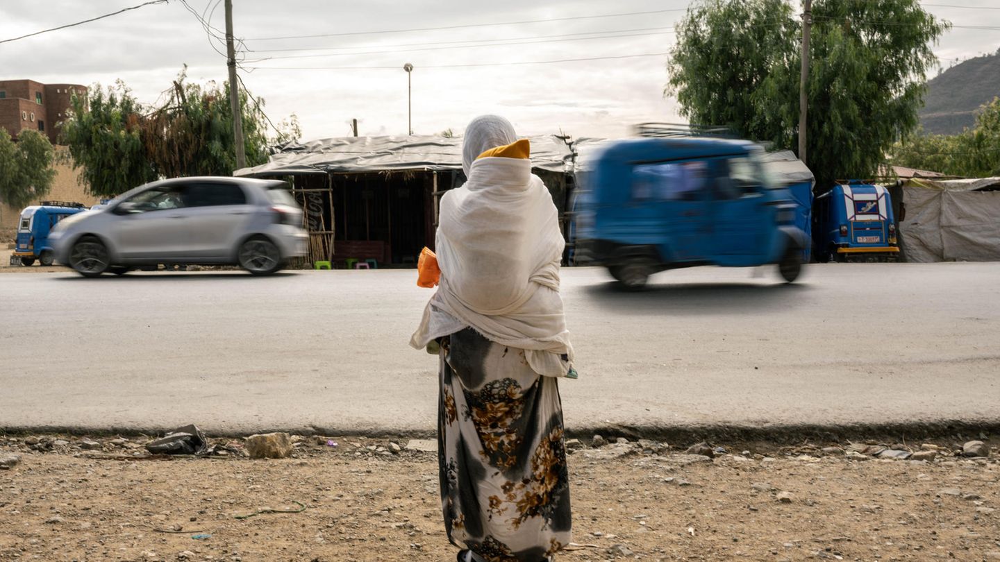 World Press Photo: Eine Frau wartet mit einem Kind auf dem Rücken am Straßenrand World Press Photo: Eine Frau wartet mit einem Kind auf dem Rücken am Straßenrand