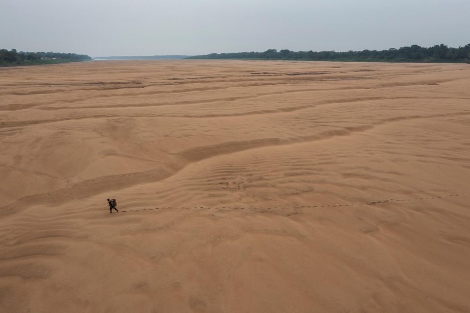 Drought in the Amazon World Press Photo: Fischer läuft durch ausgetrocknetes Flussbett