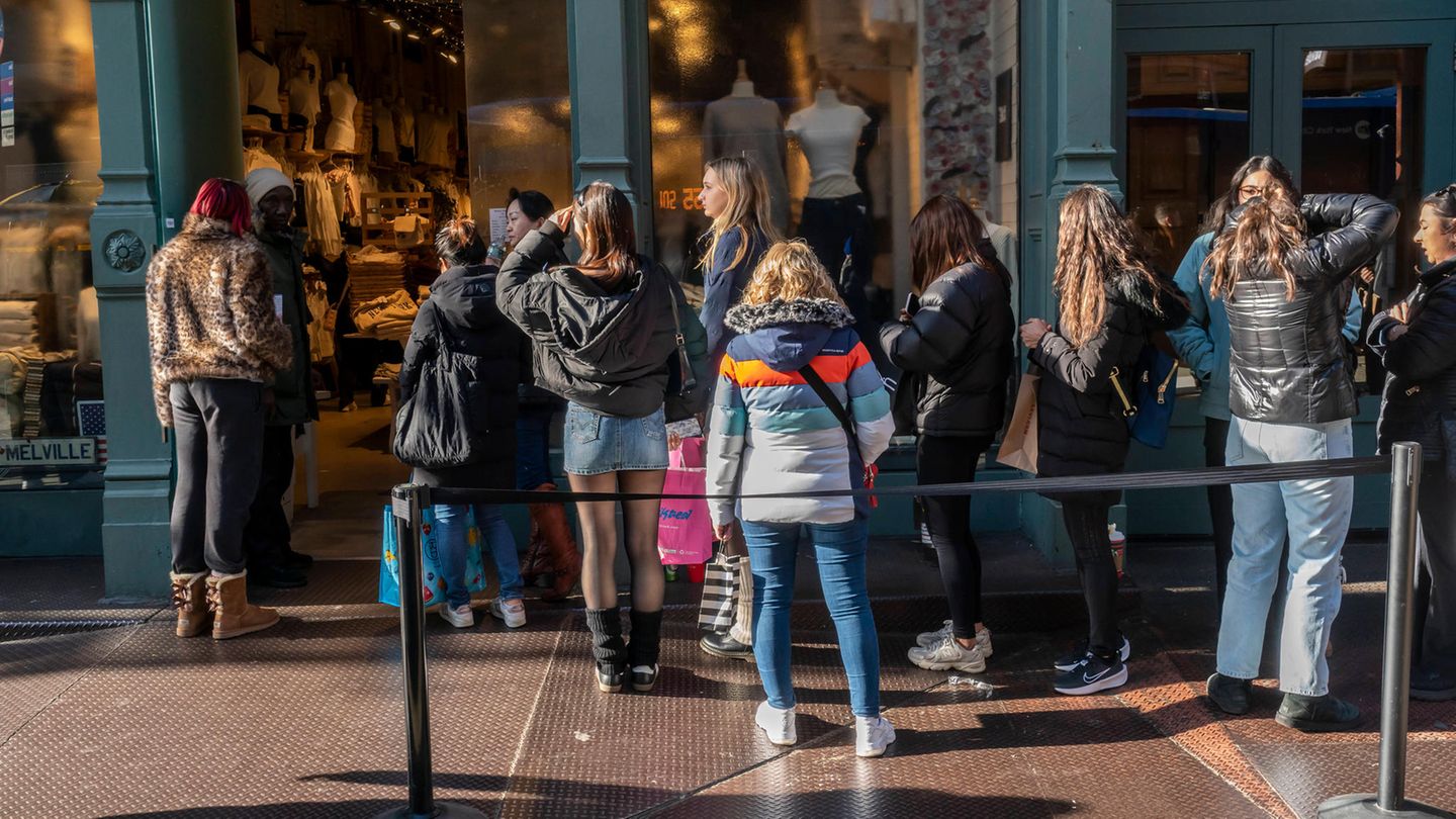 Teenager stehen Schlange vor einem Geschäft von Brandy Melville Teenager stehen Schlange vor einem Geschäft von Brandy Melville