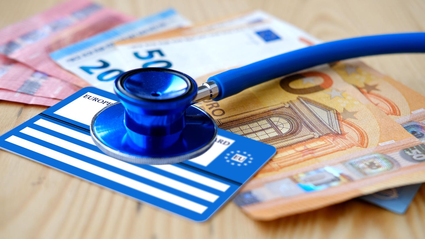 Stethoskop und Gesundheitskarte liegen auf einigen Euro-Banknoten