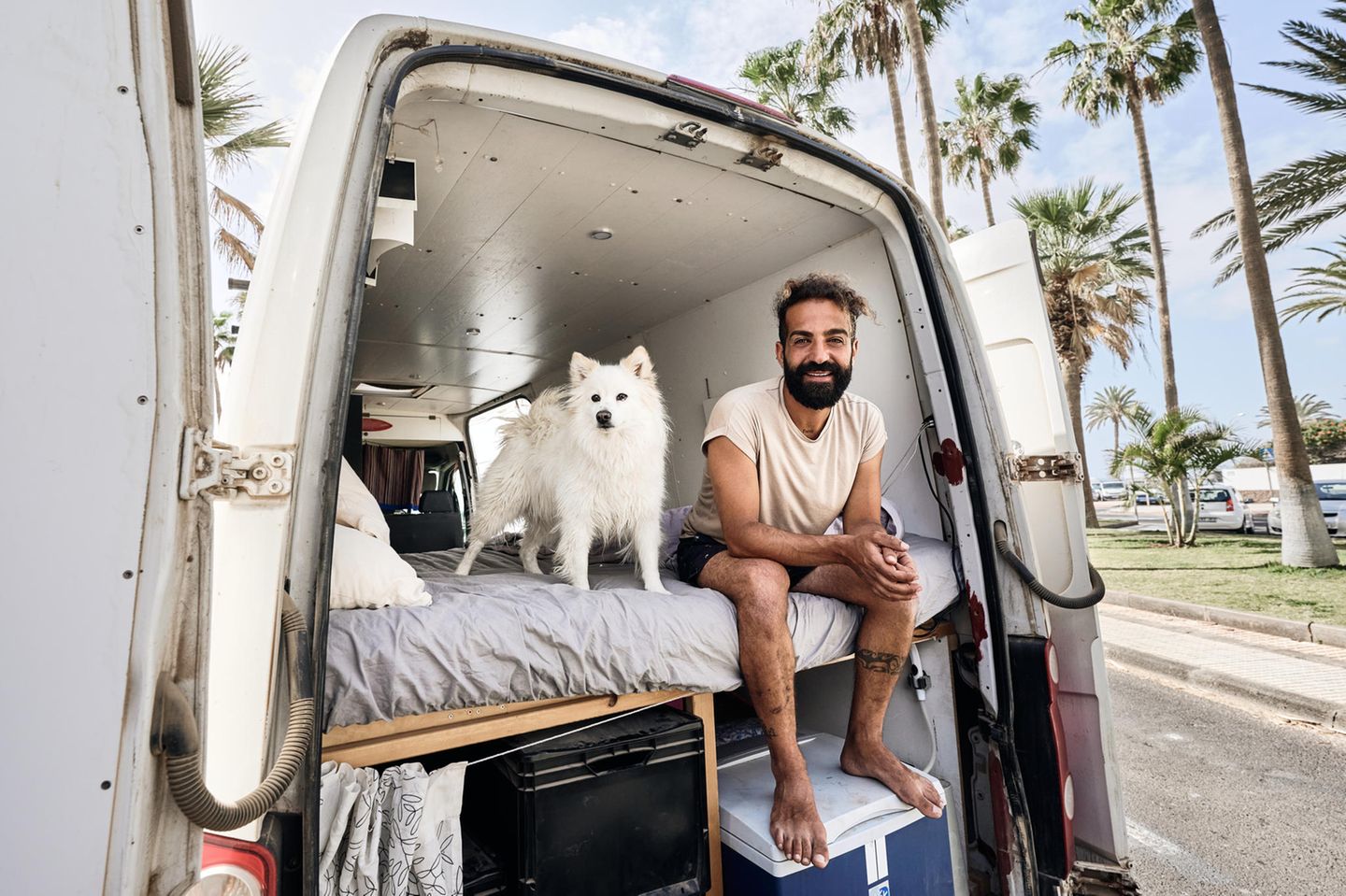 Karim mit seinem Hund sitzend im Van