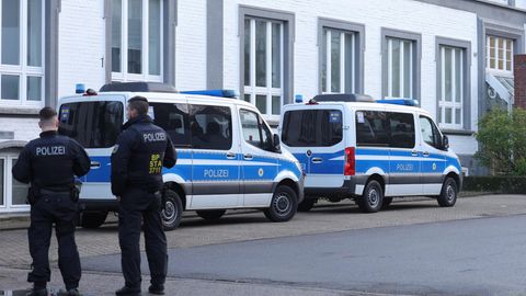 Polizisten stehen vor einem Gebäude in Solingen im Rahmen einer Razzia gegen Schleuserbanden