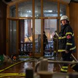 Feuerwehrleute begehen einen verwüsteten Bereich