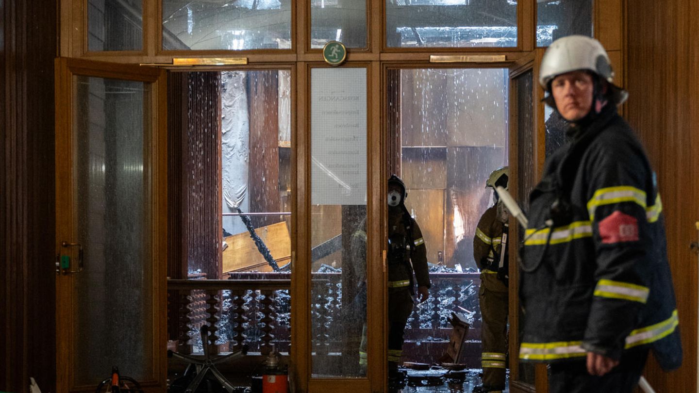 Feuerwehrleute begehen einen verwüsteten Bereich