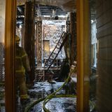 Ein Feuerwehrmann begeht einen verwüsteten Bereich der ehemaligen Börse