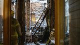 Ein Feuerwehrmann begeht einen verwüsteten Bereich der ehemaligen Börse