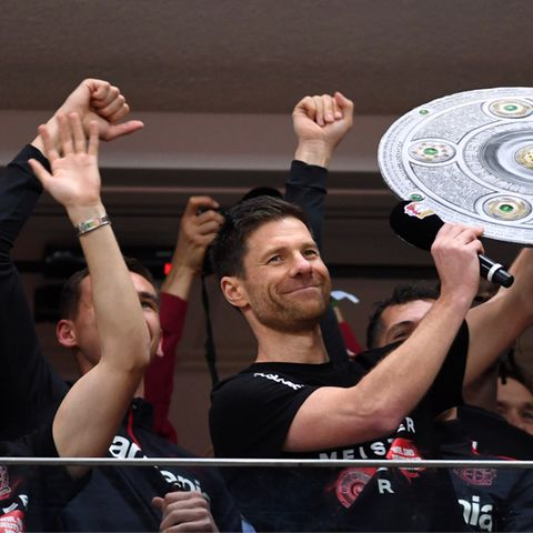 Trainer Xabi Alonso und seine Spieler jubeln mit einer Nachbildung der Meisterschale