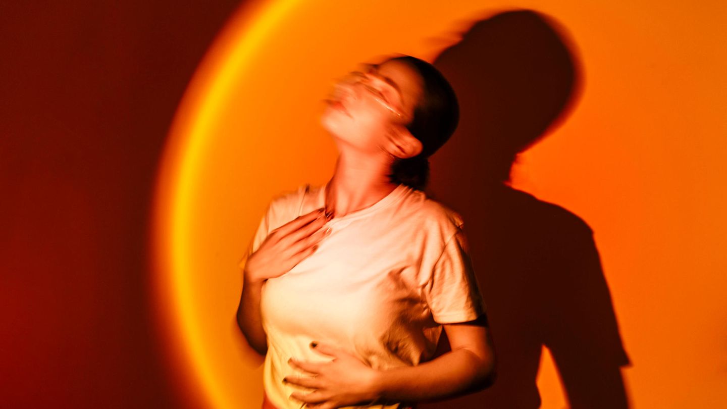 Eine Frau legt ihre Hände auf den Oberkörper, mentale Gesundheit (Symbolbild)