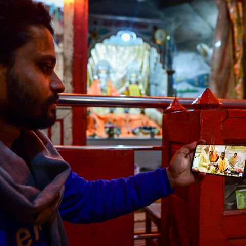 Ein Mann im indischen Ayodhya sieht sich die Einweihungszeremonie aus einem Hindu-Tempel per Livestream auf dem Handy an