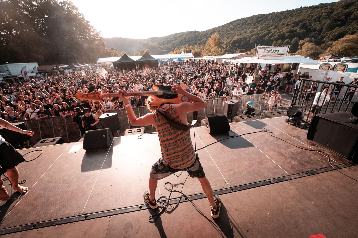 Ein Bassist spielt hinter seinem Rücken auf der Bühne