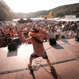 Ein Bassist spielt hinter seinem Rücken auf der Bühne