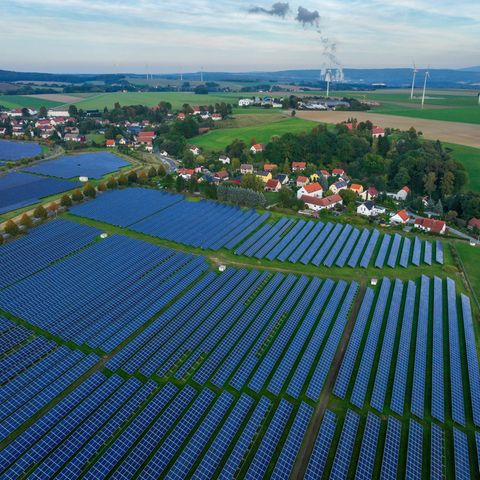 Freiflächen-PV-Anlage bei Zittau in Sachsen. Dahinter: Windräder und das Braunkohle Kraftwerk Turow in Polen. 