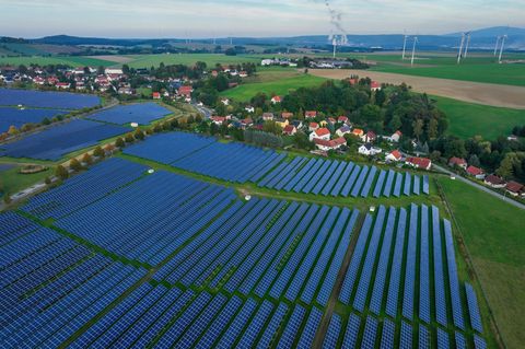 Freiflächen-PV-Anlage bei Zittau in Sachsen. Dahinter: Windräder und das Braunkohle Kraftwerk Turow in Polen. 