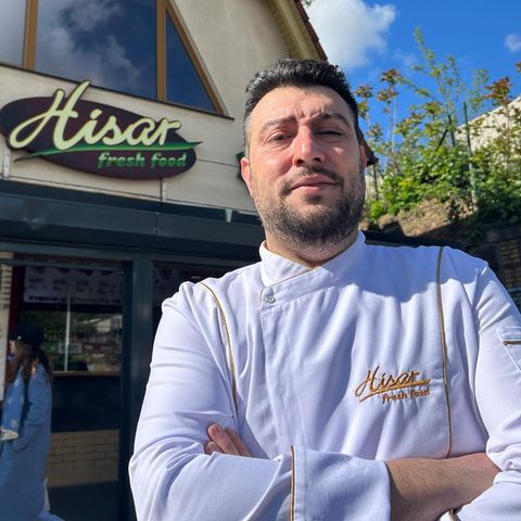 Imbissbetreiber Arif Keles steht in weißer Kochjacke vor seinem Dönerladen