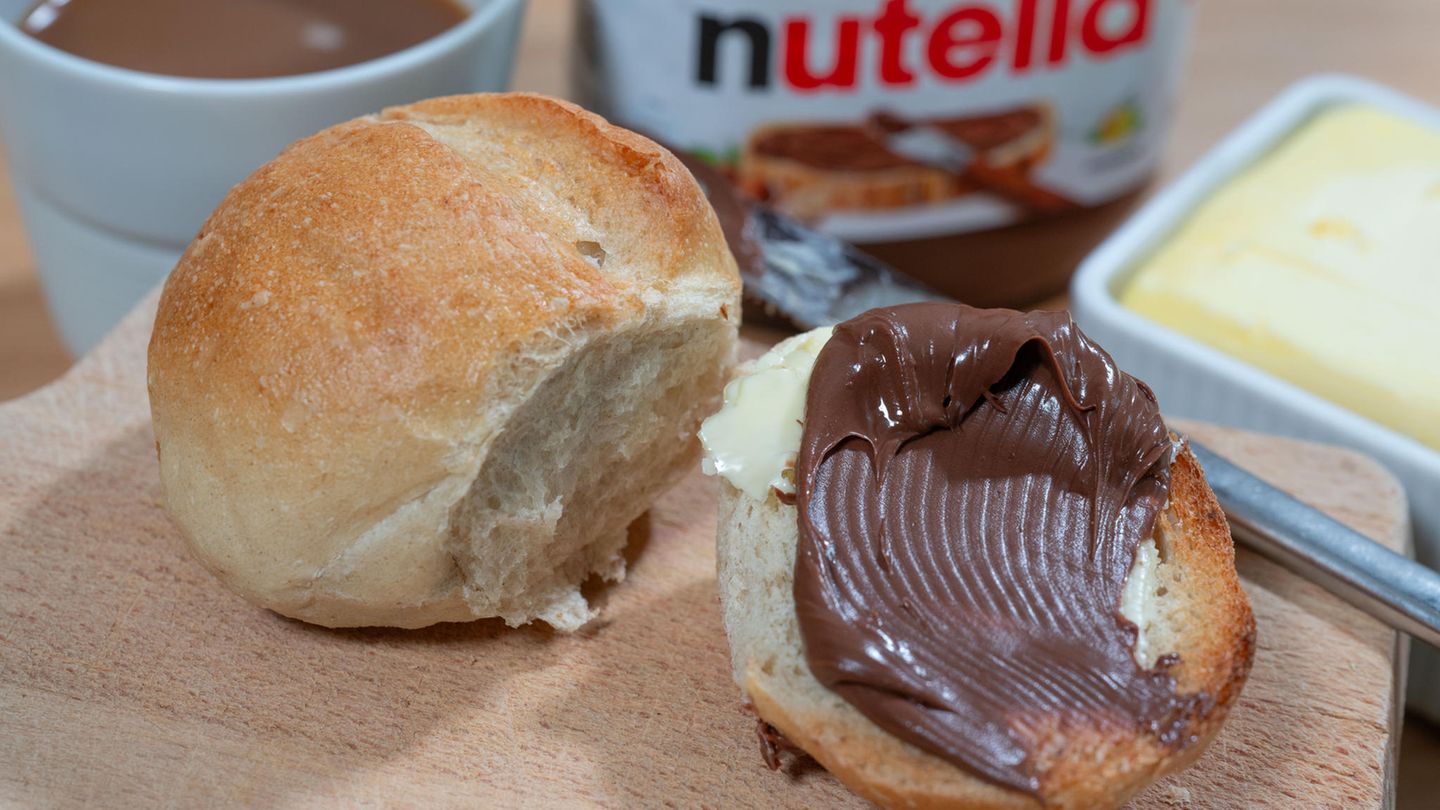Ein Brötchen mit Nutella bestrichen liegt auf einem Teller