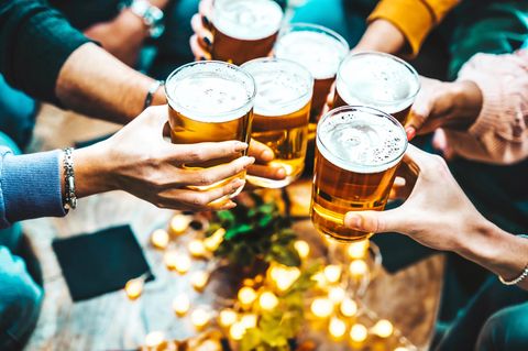 Foto zeigt Hände mit gefüllten Biergläsern beim Zuprosten
