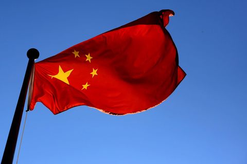 Die Flagge von China weht vor blauem Himmel