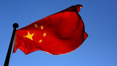 Die Flagge von China weht vor blauem Himmel