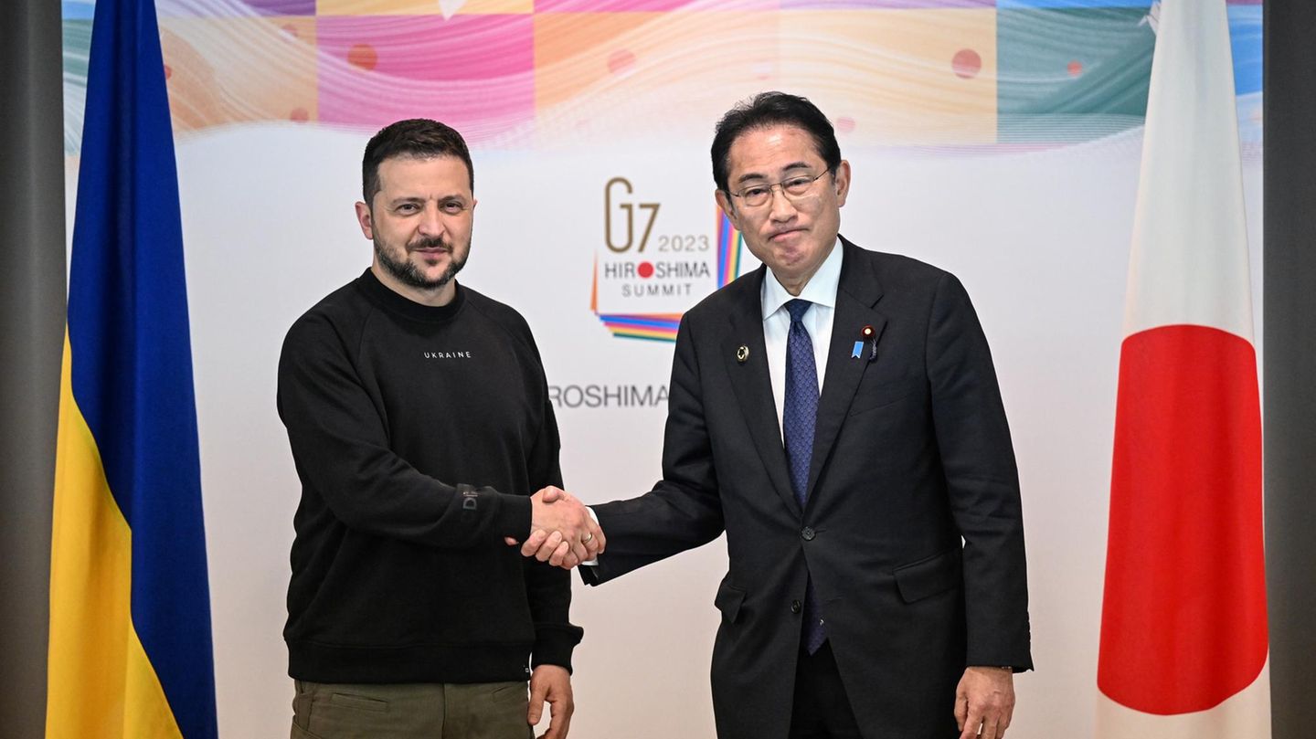 Ukraines Präsident Wolodymyr Selenskyj schüttelt Japans Premierminister Kishida Fumio die Hand