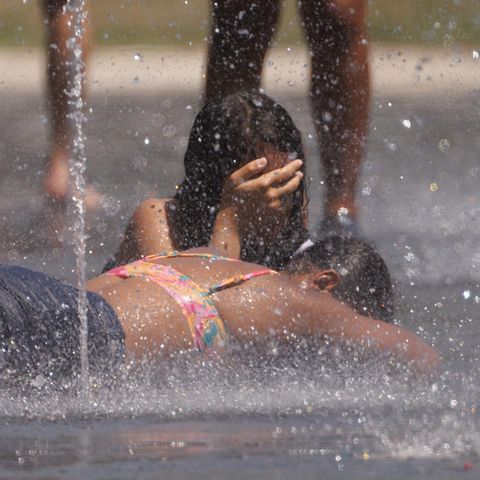 In Madrid kühlen sich Kinder an kleinen Wasserfontänen ab