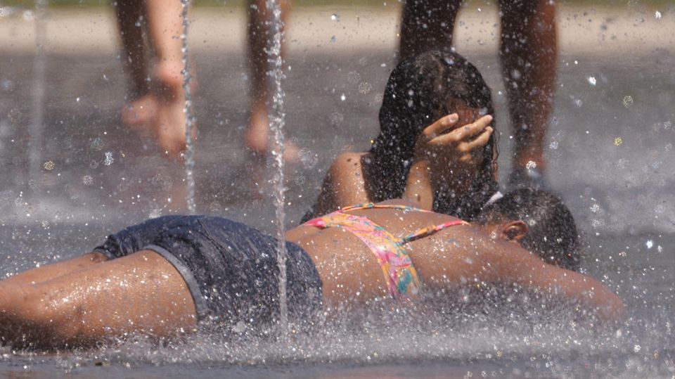 In Madrid kühlen sich Kinder an kleinen Wasserfontänen ab