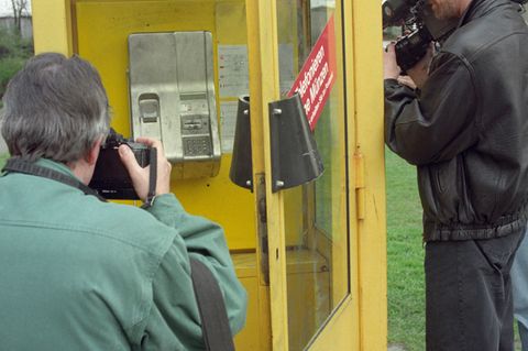 Ein Kameramann und ein Fotograf stehen am 22. April 1994 vor der Telefonzelle in Berlin, in der "Dagobert" festgenommen wurde