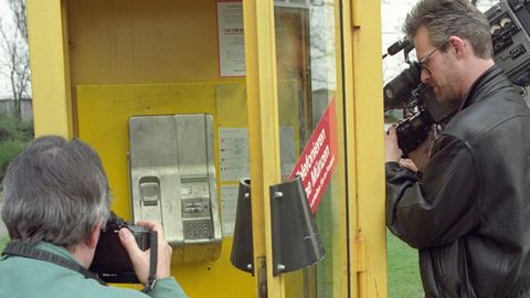 Ein Kameramann und ein Fotograf stehen am 22. April 1994 vor der Telefonzelle in Berlin, in der "Dagobert" festgenommen wurde