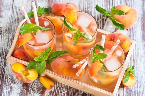 Hausgemachte Limonade mit reifen flachen saturnförmigen Pfirsichen und frischer Minze
