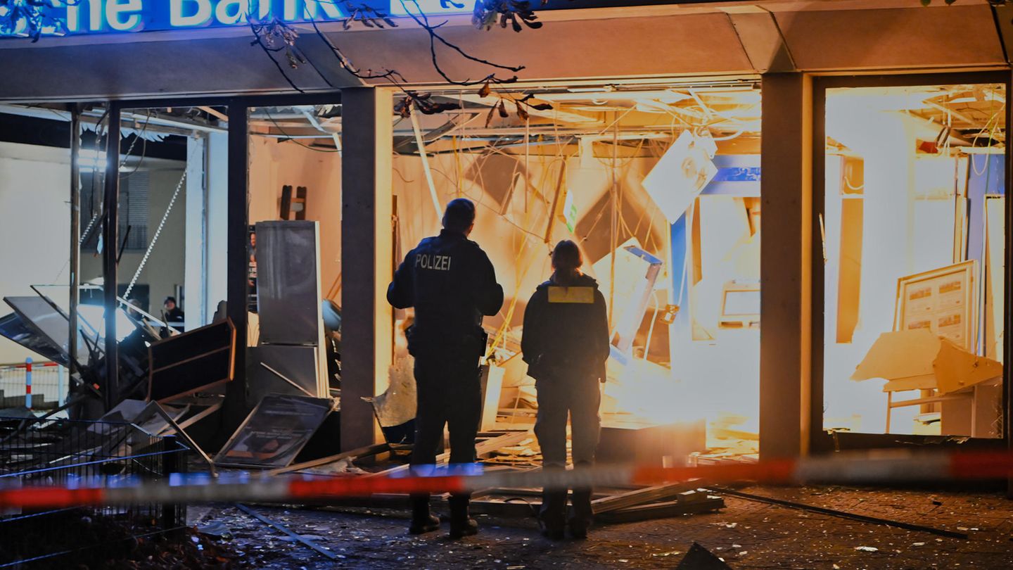 Polizisten stehen vor einer zerstörten Bankfiliale