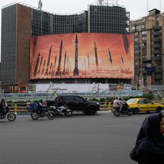Ein riesiges Plakat an einer viel befahrenen Straße in Teheran zeigt mehrere Raketen im Sonnenuntergang