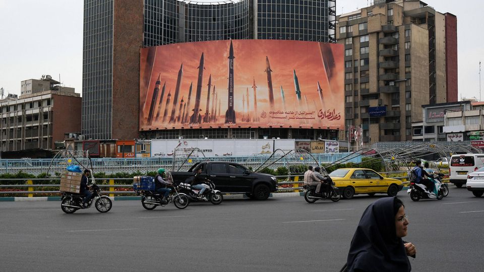 Ein riesiges Plakat an einer viel befahrenen Straße in Teheran zeigt mehrere Raketen im Sonnenuntergang