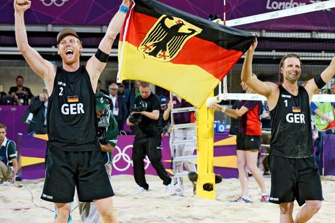 Jonas Reckermann (l.) und Julius Brink feiern ihren Olympiasieg in London 2012 mit einer Deutschlandfahne in der Hand