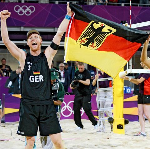 Jonas Reckermann (l.) und Julius Brink feiern ihren Olympiasieg in London 2012 mit einer Deutschlandfahne in der Hand